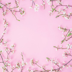 Obraz premium Floral frame with white flowers on pastel pink background. Flat lay, top view.