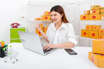 women working laptop computer from home on wooden floor with postal parcel, Selling online ideas concept, Women selling online start up small business owner working with using laptop