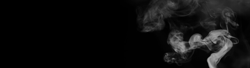 White smoke on a black background. Texture of smoke. Clubs of white smoke on a dark background for an overlay