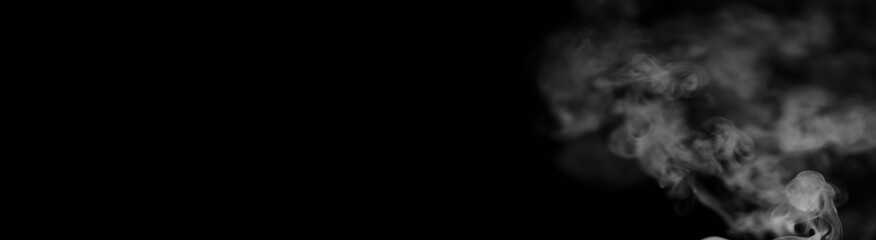 White smoke on a black background. Texture of smoke. Clubs of white smoke on a dark background for an overlay