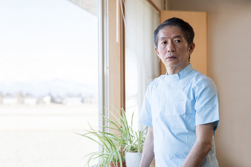 窓際に立つ医師
