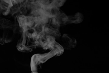 Obraz premium White smoke on a black background. Texture of smoke. Clubs of white smoke on a dark background for an overlay