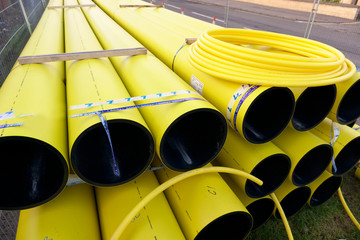 Gas yellow pipes and coil stacked on pallet at construction road works