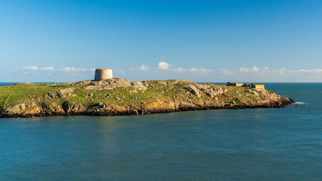 Uninhabited green small island in the Irish Sea with a derelict church and an abandoned defensive fort also known as a Martello Tower. Dalkey Island in Dublin, Ireland.