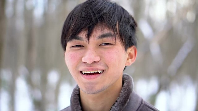 Happy Smiling Young Asian Man In Snowy Winter Scene