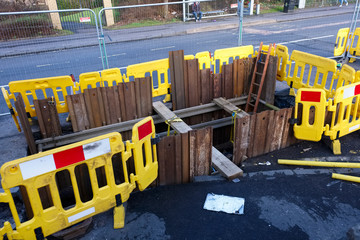 Excavation and safety fence deep in road works and piling of hole