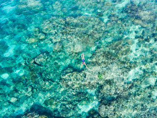 Naklejka na ściany i meble Aerial top down people snorkeling on coral reef tropical caribbean sea, turquoise blue water. Indonesia Wakatobi archipelago, marine national park, tourist diving travel destination