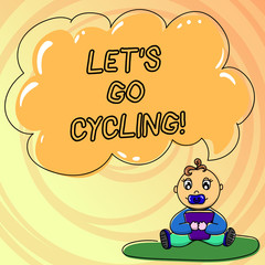 Writing note showing Let S Is Go Cycling. Business photo showcasing inviting someone to sport or activity of riding bicycle Baby Sitting on Rug with Pacifier Book and Cloud Speech Bubble