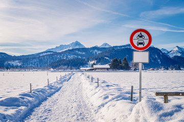 Warning sign on the snowy road in the European Alps at winter