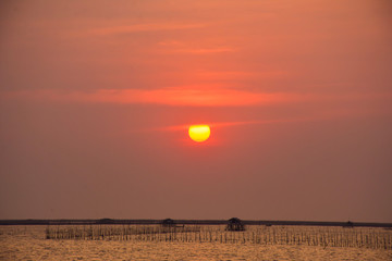 Beautiful sunset above sea in Thailand, Light orange sunset sky with seaside landscape view, peaceful background on coast of sea, Yellow sky in dawn time with copy space for create your text