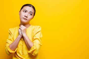 Sad woman isolated over yellow background