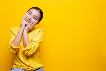 Woman feel shy standing isolated over yellow background