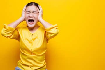 Angry woman screaming isolated over yellow background