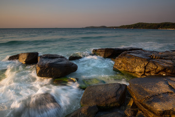 Fototapeta na wymiar Beautiful sunrise over the beach in Ko Samet, rocks and sea waves, Thailand