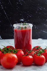 Tomato juice garnished with a rosemary branch and fresh ripe red cherry tomatoes