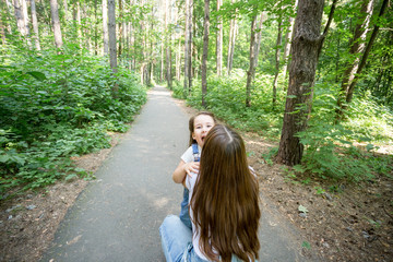 Family, nature, people concept - mother and daughter hugging in the park