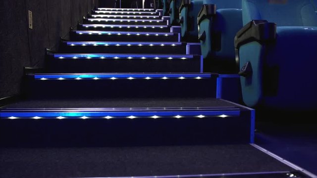 Staircase between seats rows in cinema and neon lightning of steps