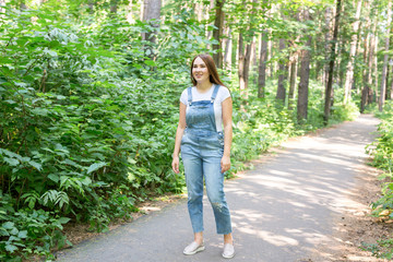 People, fashion and nature concept - Portrait of beautiful young stylish woman dressed in white t-shirt and jeans