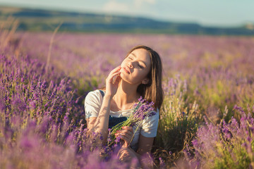 Beautiful young girl enjoying the sunlight in a lavender field