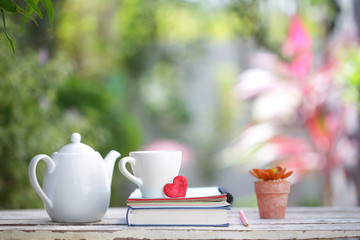 White kettle and cup with red heart and notebooks