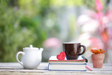 White kettle and brown cup with red heart and notebooks