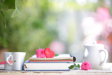 White kettle and cup with red heart and notebooks