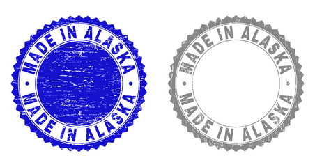 Grunge MADE IN ALASKA stamp seals isolated on a white background. Rosette seals with grunge texture in blue and gray colors. Vector rubber stamp imprint of MADE IN ALASKA tag inside round rosette.