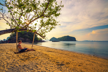 Young boy enjoys sunset n Ko Hong island in Thailand