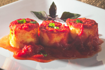 Traditional Italian Rondelli pasta with tomato sauceon rustic background