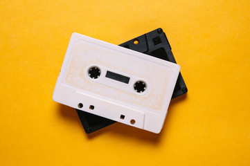 Obraz premium White and black audio cassette on yellow background
