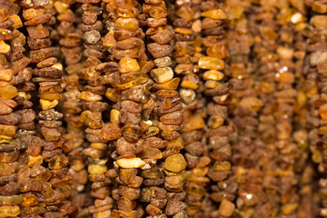 Amber background. Texture of amber beads. A lot of amber pieces strung on a thread.