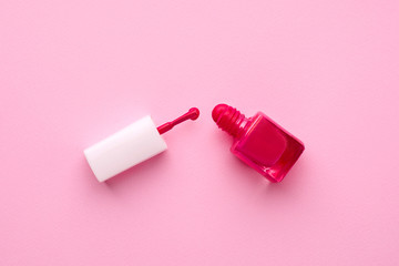 Cosmetic nail polish pink color with brush on a pink background