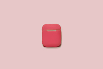Little white earphones with charger box in bright pink cover box, chosen focus. Greyish pink...