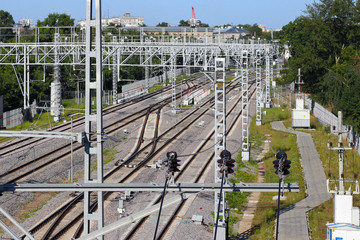 Railway tracks go into the distance. Railway power lines. Lines, diagonals, rhythm. City. Industrial landscape. Summer, clear Sunny day.