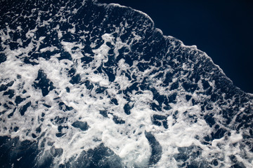 Aerial top view of sea waves hitting rocks on the beach with turquoise sea water. Amazing rock cliff seascape in the coastline. Aerial view of sea waves and fantastic Rocky coast. Mediterranean Sea.