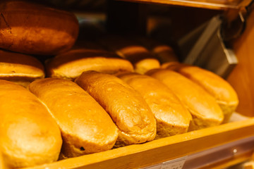 Bread Shop. Fresh tasty bread are on the shelves. Variety of delicious breads displayed on shelves in bakery