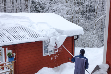  Schneeräumen auf dem Dach mit einem speziellen Schneeschieber