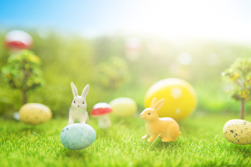Easter rabbits on green grass with Easter eggs in Dreamland or fairy world
