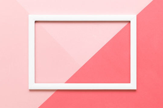 Abstract geometrical living coral and pastel pink paper flat lay background. Minimalism, geometry and symmetry template with empty picture frame mock up.