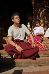 Jeune homme caucasien et femme asiatique devant un temple Thaïlande