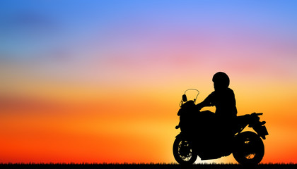 Fototapeta na wymiar Silhouette biker with his motorbike beside the natural lake and beautiful sunset sky.