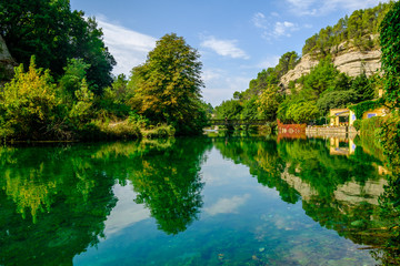 Fototapeta na wymiar Village de Fontaine-de-Vaucluse, Provence, France. La rivière Sorgue en été. Paysage coloré en vert. 