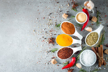 Spices in Wooden spoon. Herbs. Curry, Saffron, turmeric, rosemary, cinnamon, garlic, pepper, anise on wooden rustic background. Collection of spices and herbs. Salt, paprika. Copy space. Top view. Ban