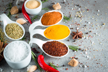 Spices in Wooden spoon. Herbs. Curry, Saffron, turmeric, rosemary, cinnamon, garlic, pepper, anise on wooden rustic background. Collection of spices and herbs. Salt, paprika. Copy space. Top view. Ban