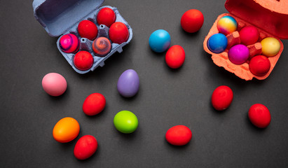 Easter eggs, pastel colors painted and a carton case, dark gray background
