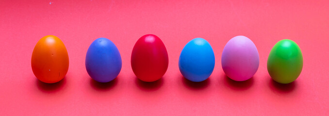 Easter eggs, pastel colors painted, standing in a row, orange color background
