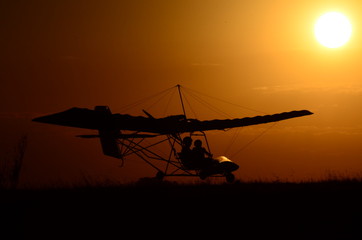 Fototapeta na wymiar Ultralight airplane at sunset.