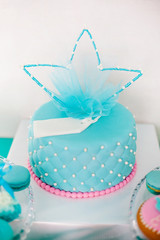 Blue and pink birthday cake with pearls big crown for little baby girl and decorations for party