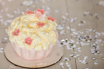 First birthday pink cake with flowers for little baby girl and decorations for cake smash