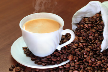 cup of coffee and beans on wooden table